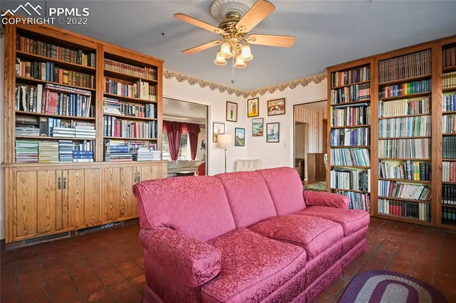 a living room with furniture and bookshelf