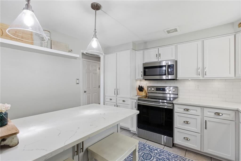 2955 Kings Mill Road Bethel Park, PA 15102 - Photo 10 of 40 a kitchen with white cabinets and stainless steel appliances