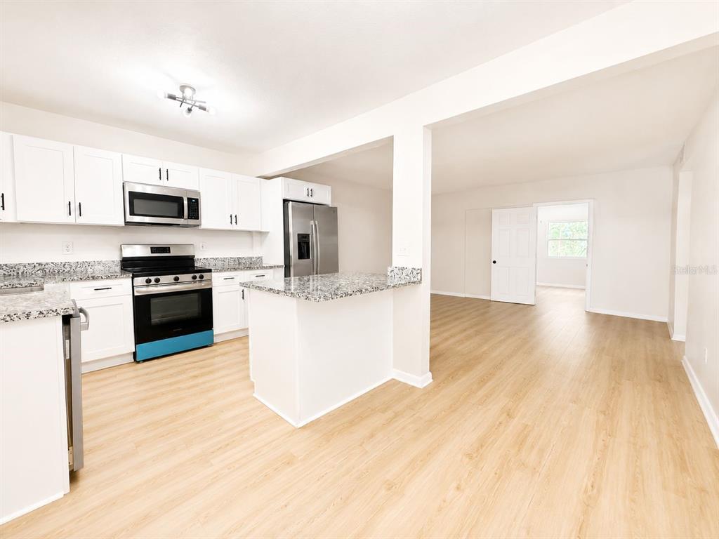 a kitchen with granite countertop a stove top oven and a sink with granite countertops