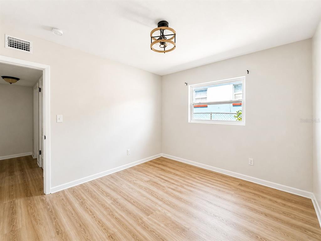 1353 Lakeview Road Clearwater, FL 33756 - Photo 11 of 15 an empty room with wooden floor and a window