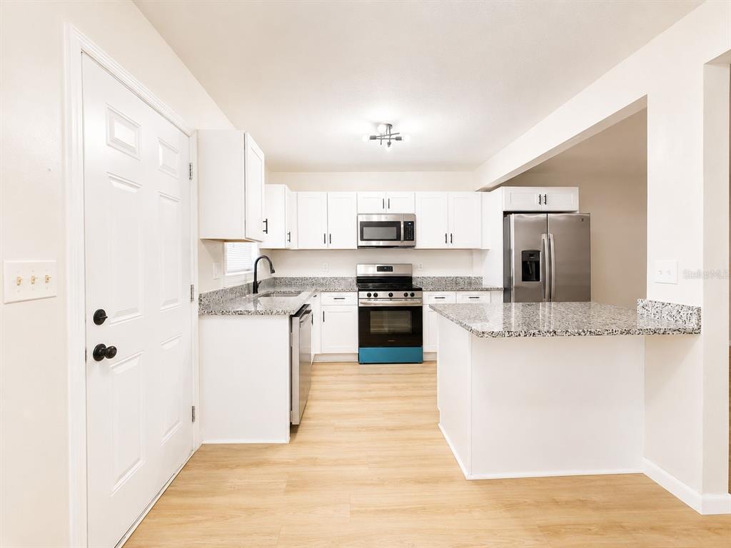 1353 Lakeview Road Clearwater, FL 33756 - Photo 4 of 15 a kitchen with granite countertop a stove top oven and cabinets
