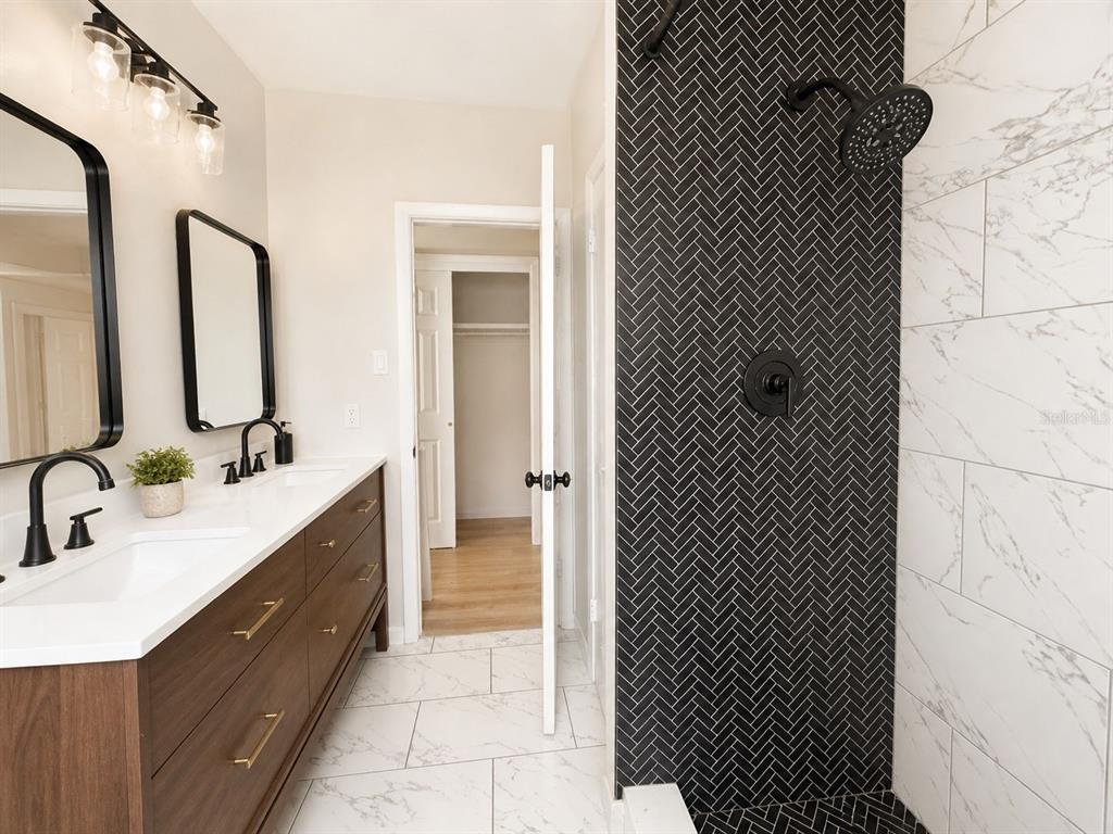 1353 Lakeview Road Clearwater, FL 33756 - Photo 7 of 15 a bathroom with a double vanity sink and mirror