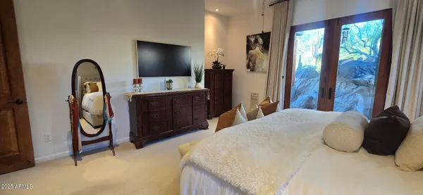 a bedroom with a bed and dresser with mirror