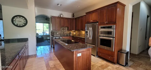 a kitchen with granite countertop a refrigerator a stove and a sink