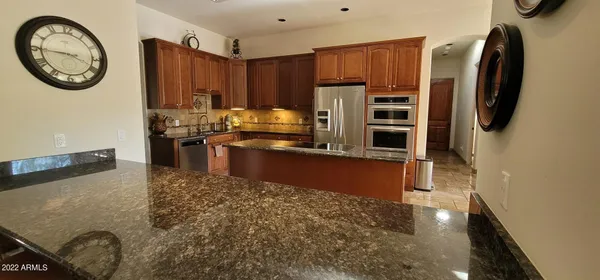 a kitchen with stainless steel appliances granite countertop a refrigerator a stove a sink and a stove