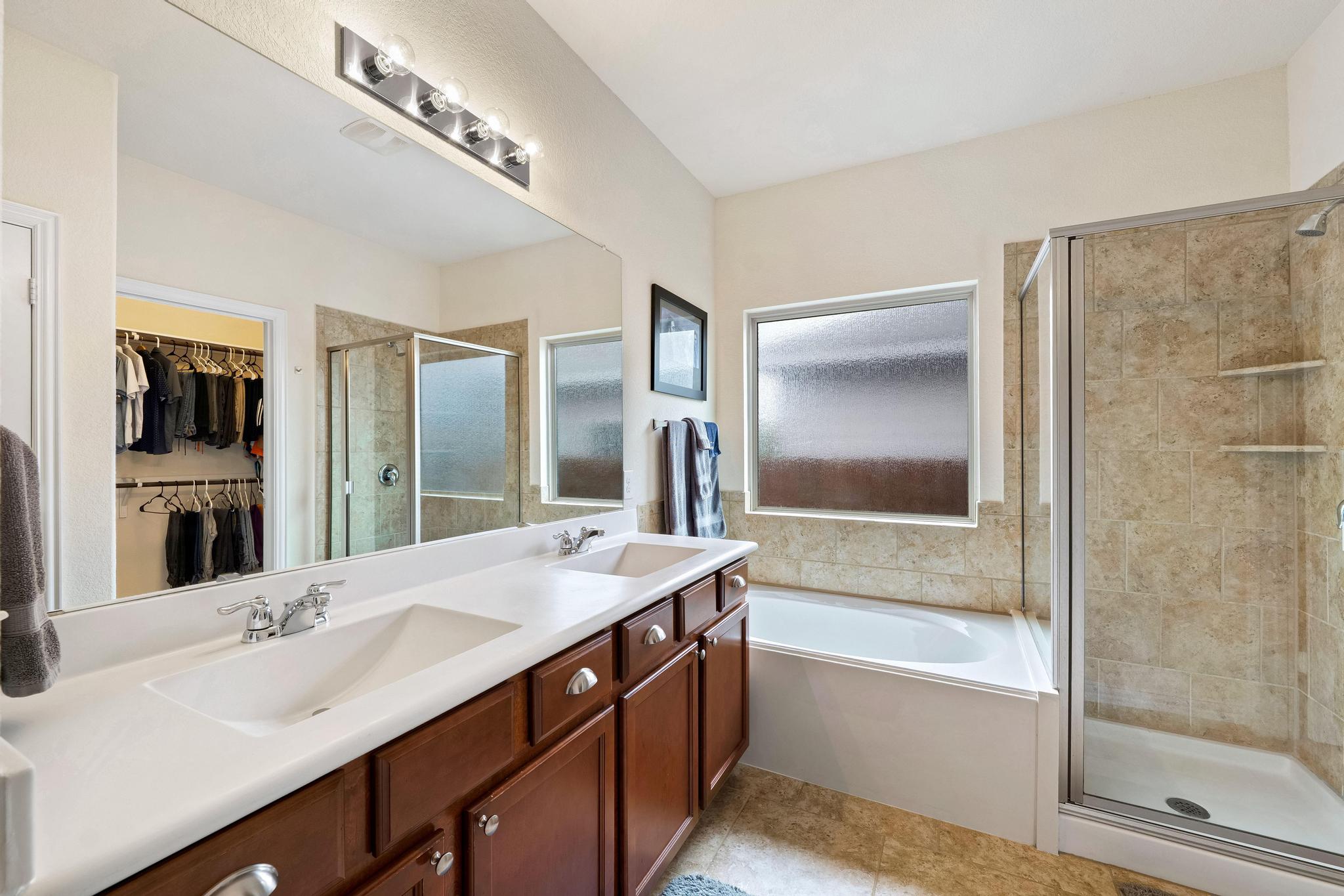 6905 Vail Ridge Street Austin, TX 78744 - Photo 15 of 39 Primary en-suite bathroom features a dual vanity, soaking tub, and separate shower