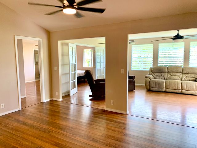 a view of a livingroom with furniture hardwood floor and windows