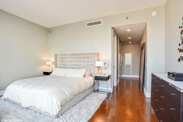 a bedroom with a bed and wooden floor