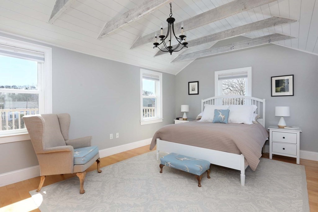 491 Webster Street Needham, MA 02494 - Photo 19 of 37 a spacious bedroom with a bed and a chair
