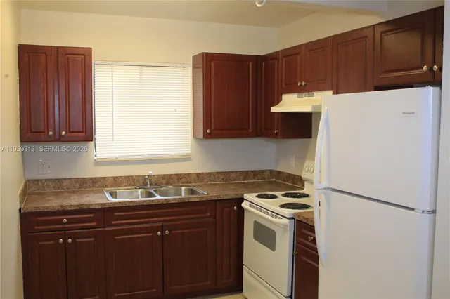 a bathroom with a granite countertop toilet sink and mirror