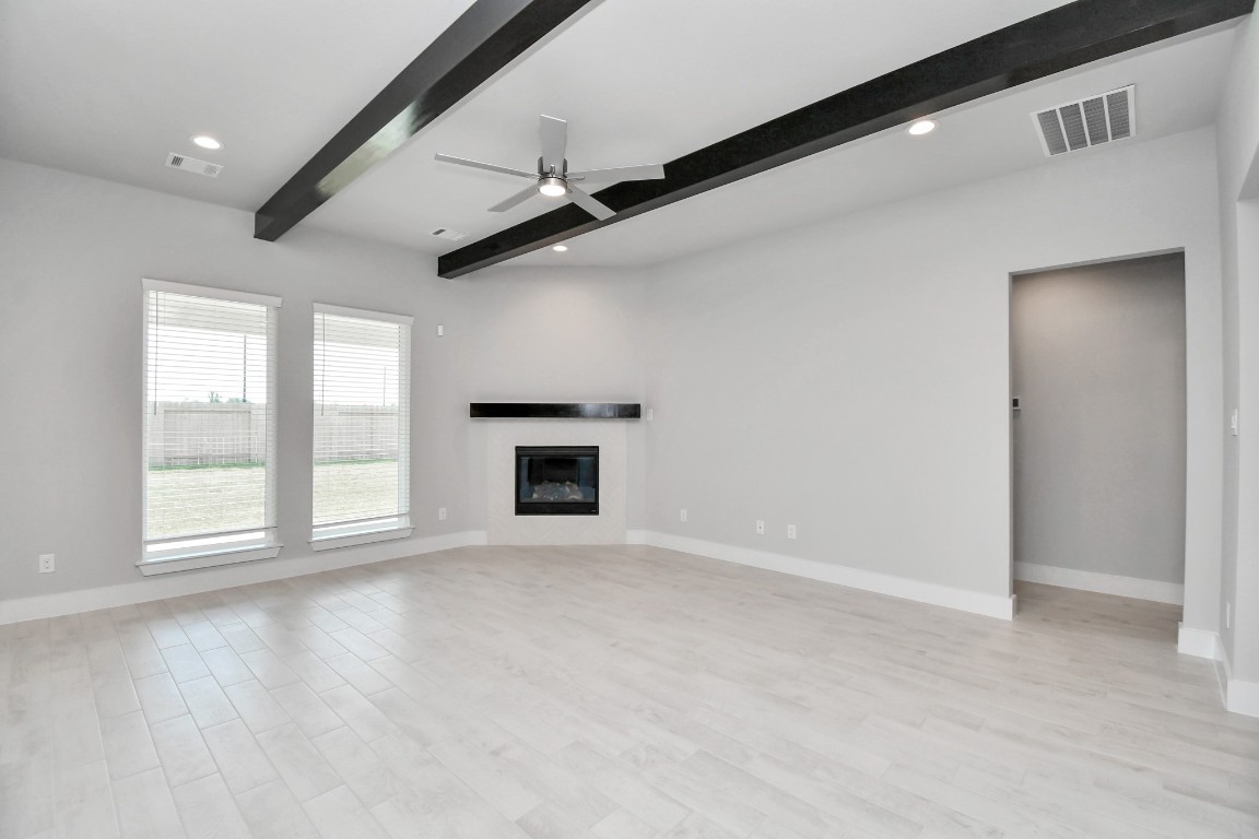 3123 Native Spg Drive Spring, TX 77373 - Photo 17 of 38 Family room flooded with natural light through the expansive windows. The premium tile flooring adds a touch of luxury to the space, creating the perfect setting for relaxing moments and cherished gatherings with loved ones. Sample photo of completed home with similar floor plan. Actual colors and selections may vary.