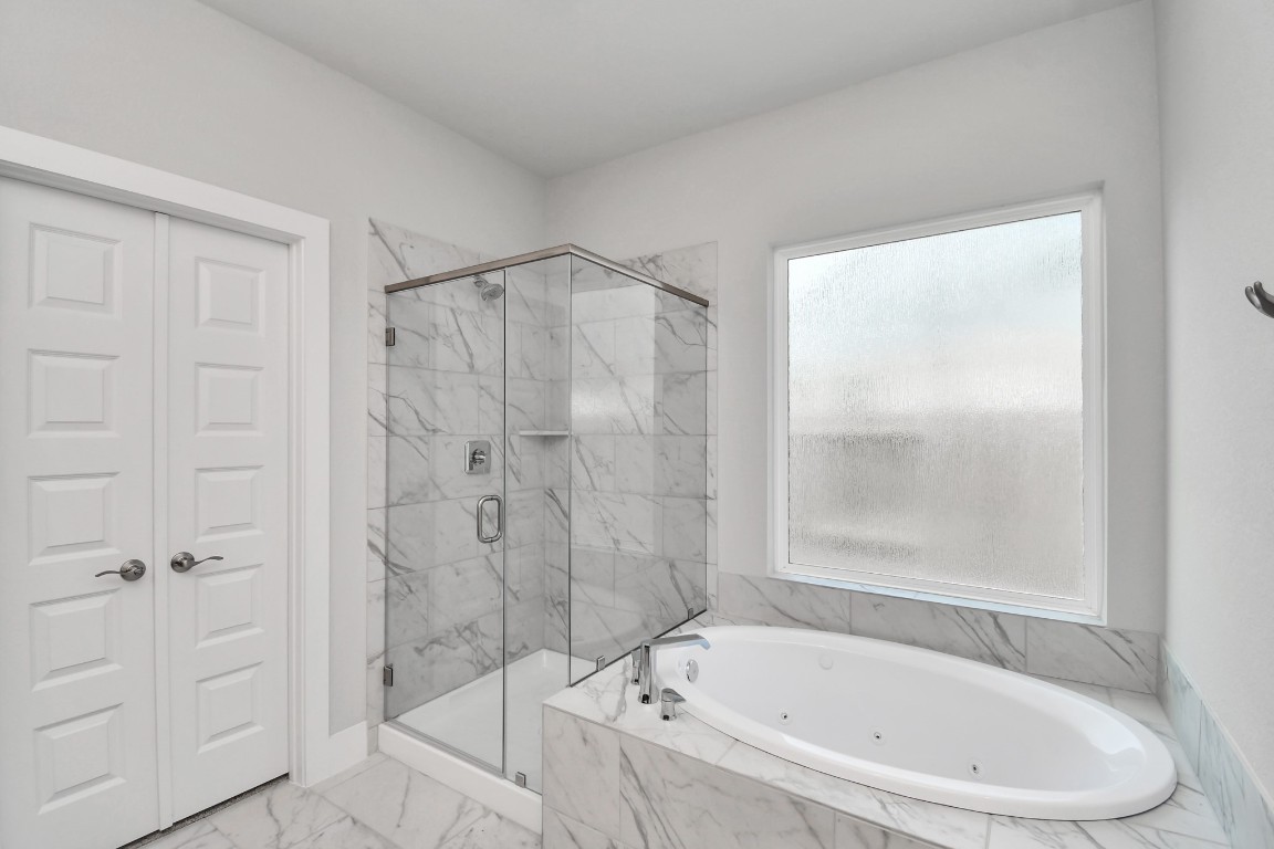 3123 Native Spg Drive Spring, TX 77373 - Photo 24 of 38 Indulge in a spa-like retreat within the confines of this primary bathroom. Delight in a spacious walk-in shower enveloped in stylish tile surround and unwind in a separate garden tub adorned with custom detailing. Sample photo of completed home with similar floor plan. Actual colors and selections may vary.