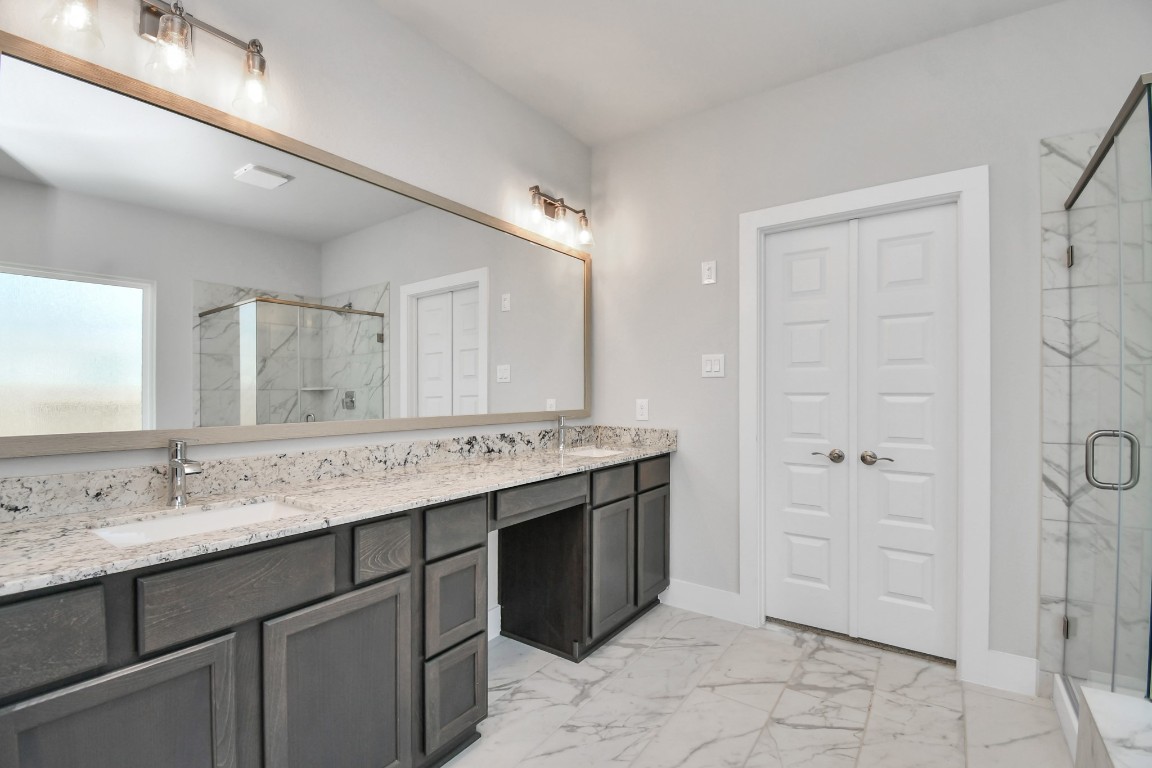 3123 Native Spg Drive Spring, TX 77373 - Photo 25 of 38 Elevate your daily routine at the elegant vanity, now equipped with double sinks, light countertops, modern hardware, and beautiful vanity lights. Sample photo of completed home with similar floor plan. Actual colors and selections may vary.