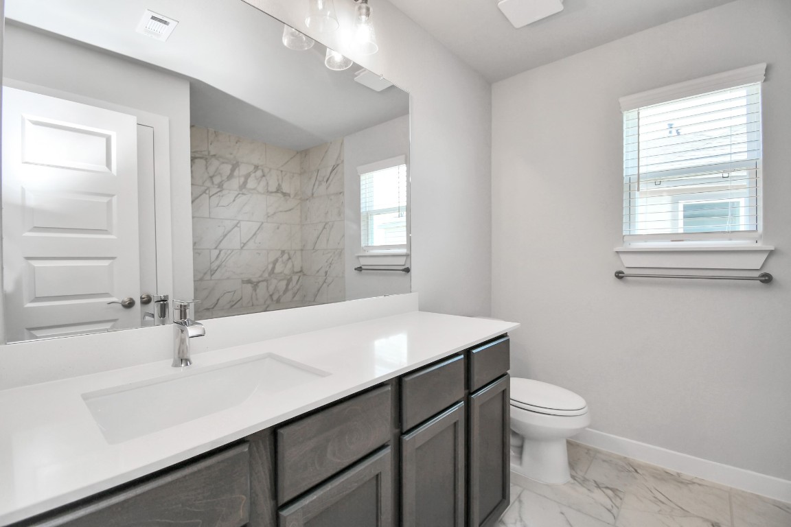 3123 Native Spg Drive Spring, TX 77373 - Photo 32 of 38 Secondary bath features tile flooring, a walk-in shower with tile surround, light stained wood cabinets, beautiful light countertop. Sample photo of completed home with similar floor plan. Actual colors and selections may vary.