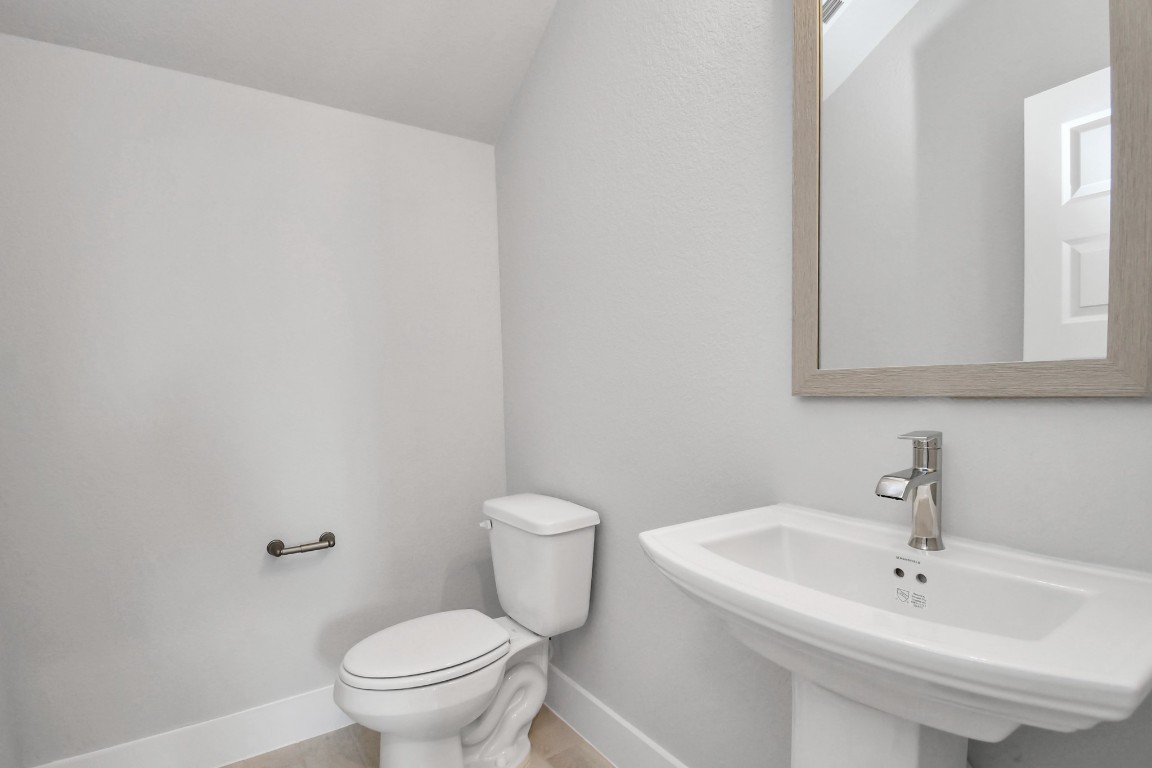 3123 Native Spg Drive Spring, TX 77373 - Photo 7 of 38 This half bathroom features a stylish pedestal sink, modern hardware, and bright recessed lighting, creating a sleek and inviting space. Sample photo of completed home with similar floor plan. Actual colors and selections may vary.