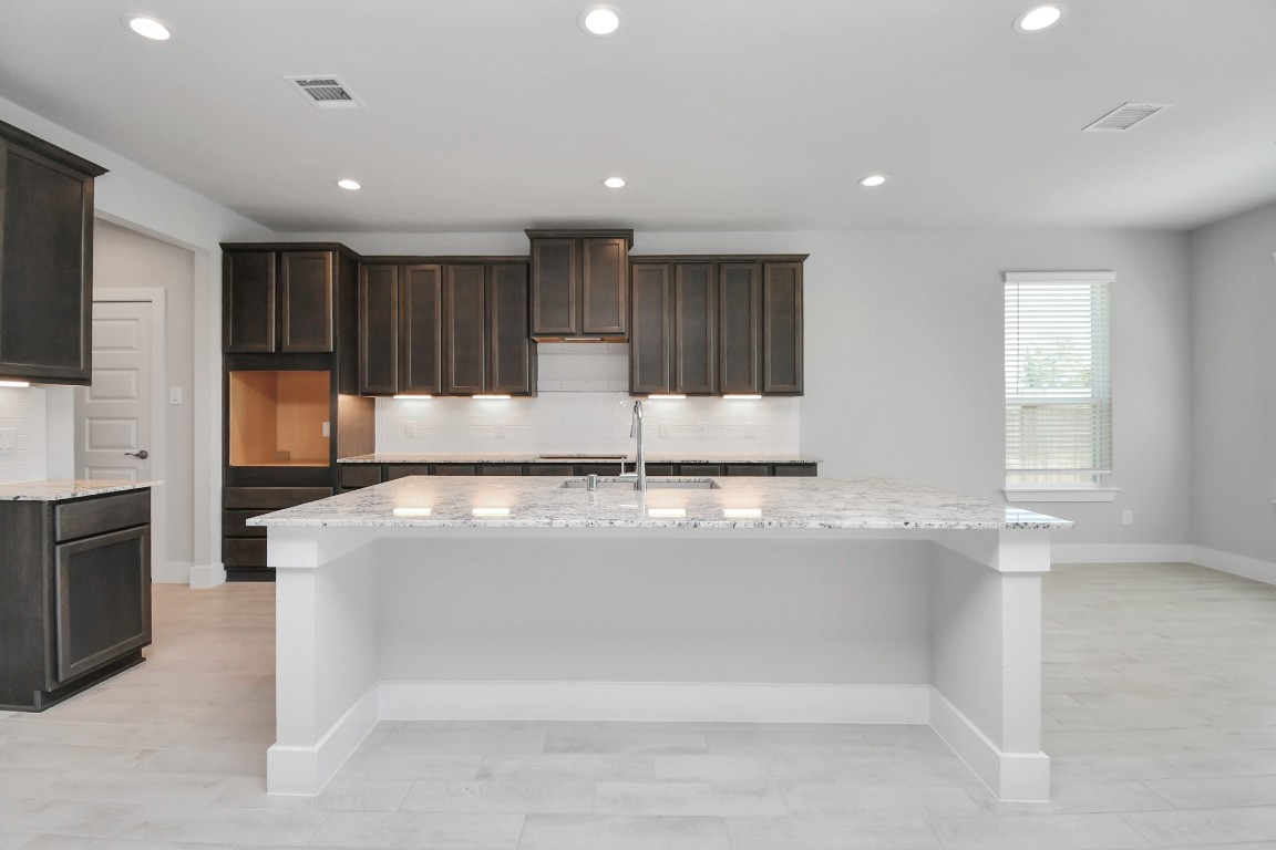 3123 Native Spg Drive Spring, TX 77373 - Photo 10 of 38 This kitchen is by far any chef’s dream! This spacious kitchen features high ceilings, stained wood cabinets, granite countertop, SS appliances, modern tile backsplash, recessed lighting, extended counter space, granite kitchen island with double sink, and space for breakfast bar, and a walk-in pantry all overlooking your huge family room. Sample photo of completed home with similar floor plan. Actual colors and selections may vary.