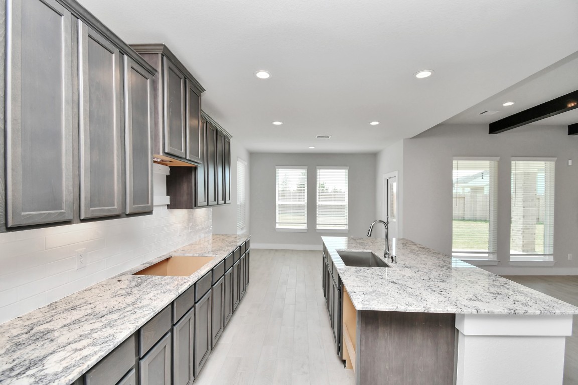 3123 Native Spg Drive Spring, TX 77373 - Photo 11 of 38 The kitchen is a culinary haven, featuring granite countertops, a tile backsplash, stainless steel appliances, 42” upper cabinets, and undercabinet lighting. Sample photo of completed home with similar floor plan. Actual colors and selections may vary.