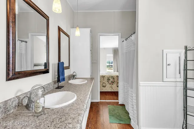 a en suite bathroom with a granite countertop sink and a mirror