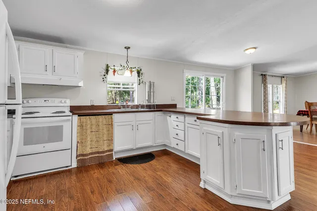 a kitchen with granite countertop white cabinets and white appliances