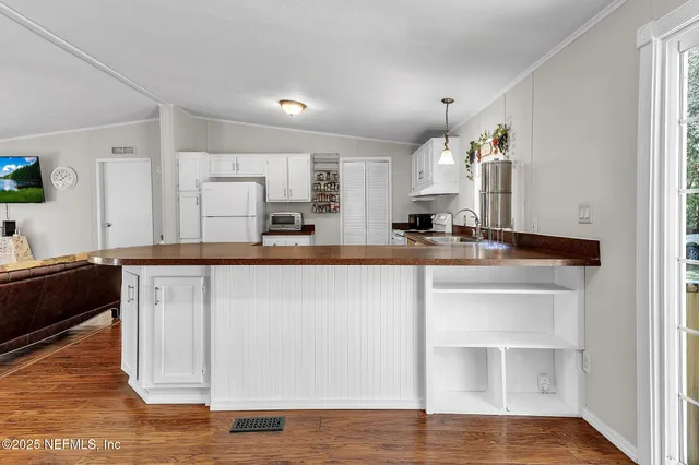 a kitchen with kitchen island granite countertop a stove cabinets and wooden floor