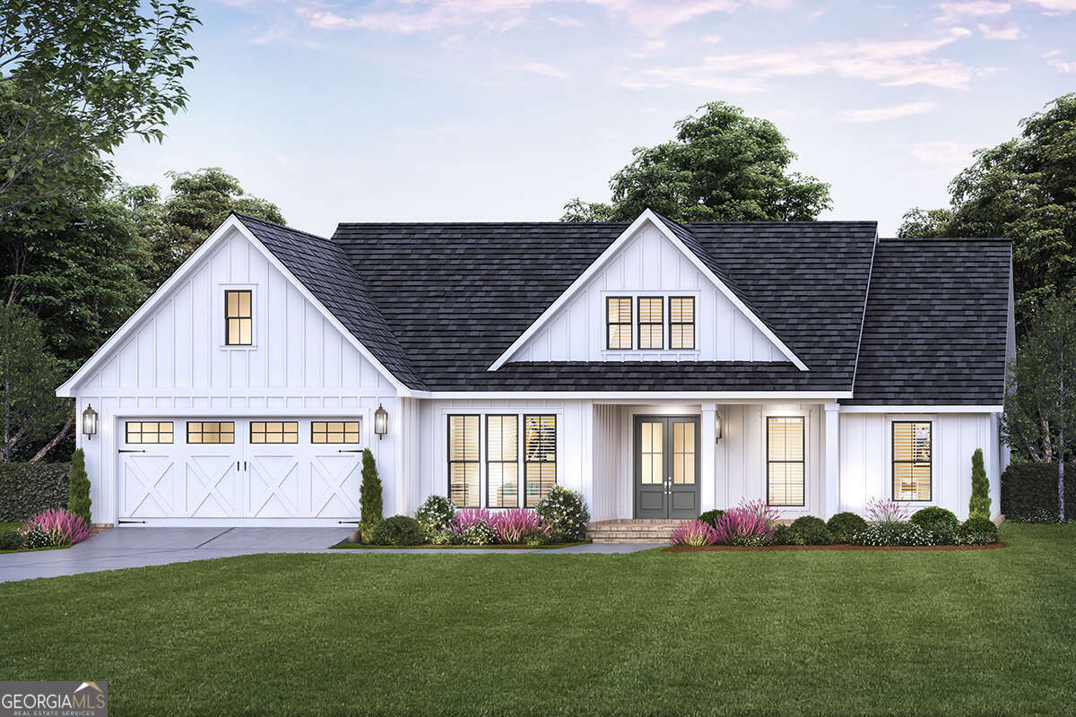 a front view of a house with a garden and yard