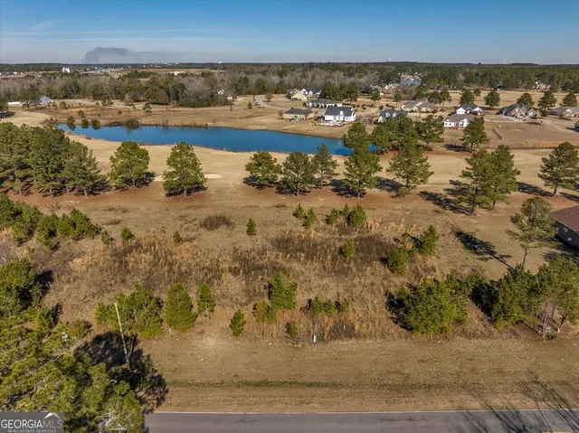 an aerial view of a house with a yard and lake view