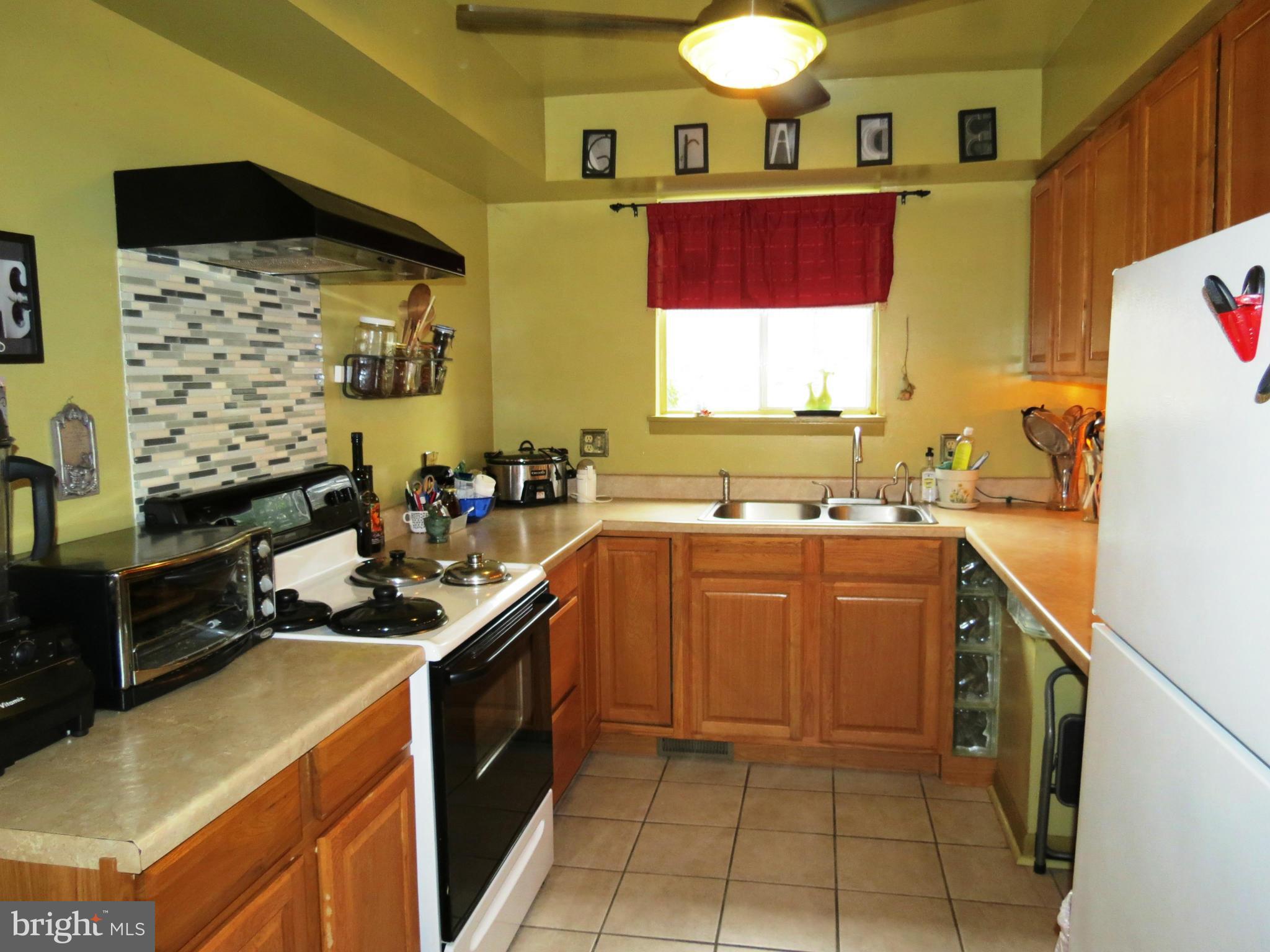 11027 Saffold Way Reston, VA 20190 - Photo 3 of 10 a kitchen with stainless steel appliances granite countertop a sink stove and refrigerator