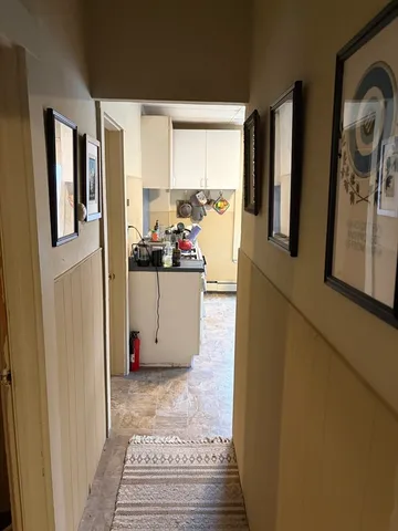 a view of a kitchen with fridge and wooden floor