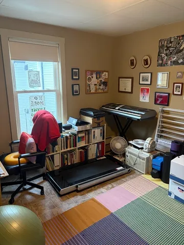a living room with furniture a rug and wall paintings