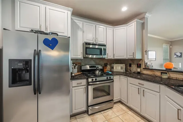 a kitchen with stainless steel appliances granite countertop a refrigerator sink and cabinets