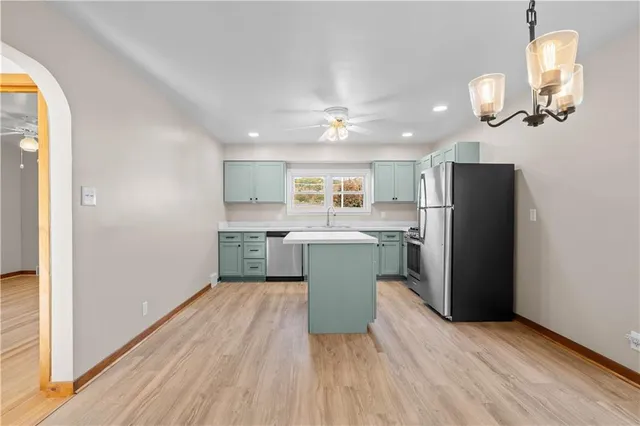 a kitchen with a refrigerator cabinets and wooden floor