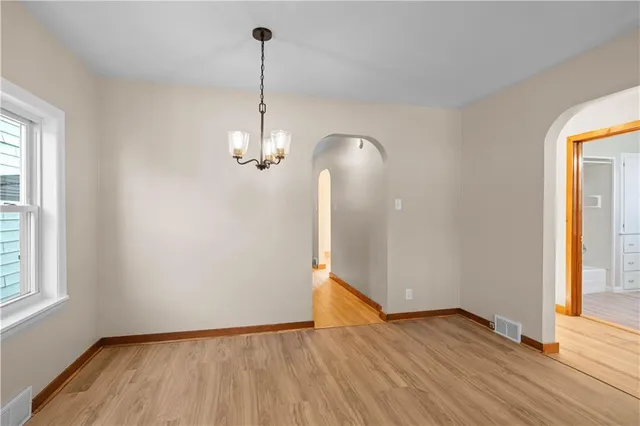 a view of empty room with wooden floor and window