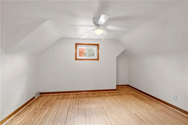 an empty room with a window and wooden floor