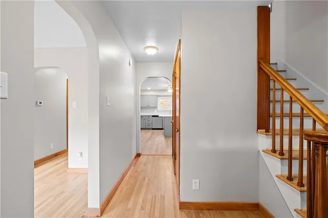 a view of a hallway with wooden floor and staircase