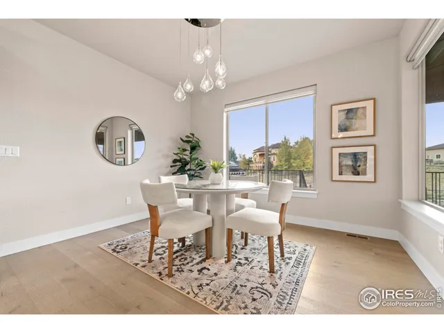 a view of a dining room with furniture a chandelier and wooden floor