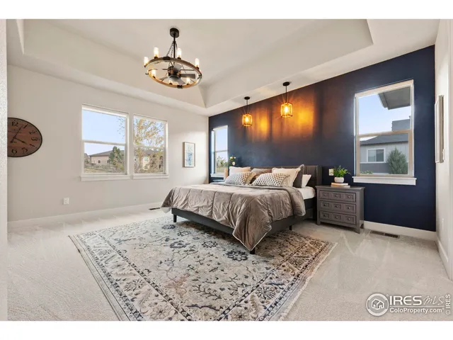 a bedroom with a large bed and a chandelier