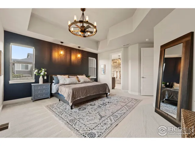 a bedroom with a large bed and a chandelier