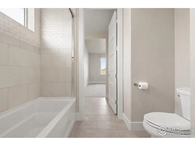 a bathroom with a tub a toilet and a shower