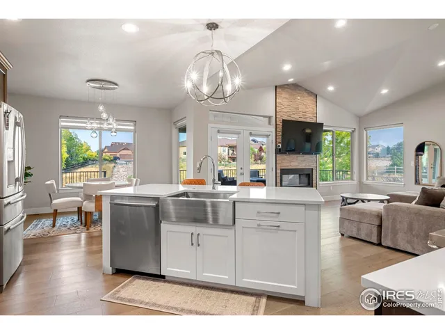 a kitchen with stainless steel appliances granite countertop a sink dishwasher a couches chairs and chandelier