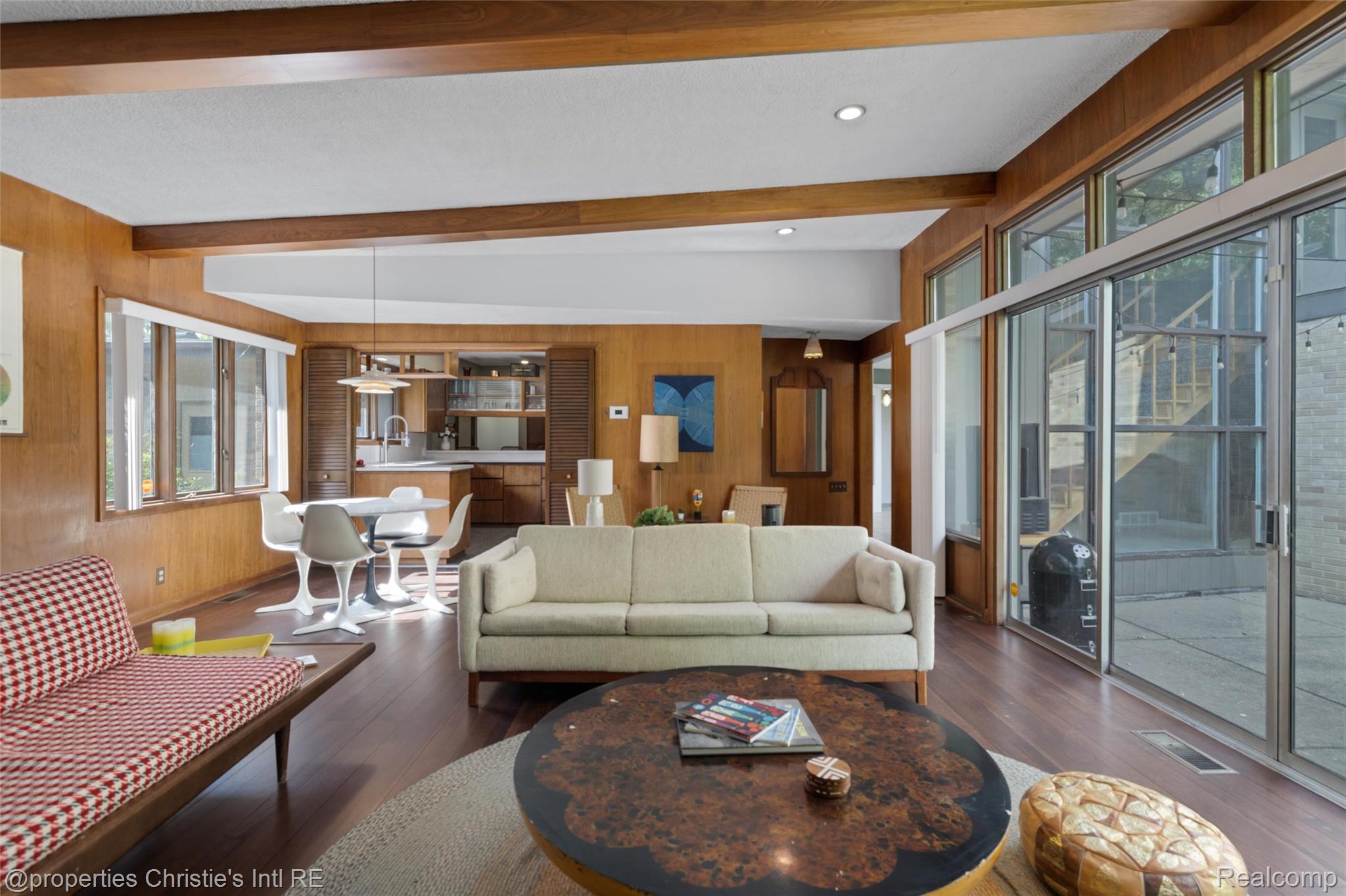 2771 West Seven Mile Road Detroit, MI 48221 - Photo 7 of 57 Spacious living area featuring wood-finish flooring, wood paneling, and exposed ceiling beams