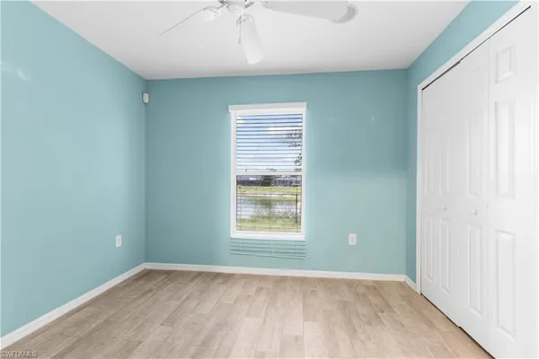 an empty room with a window and wooden floor