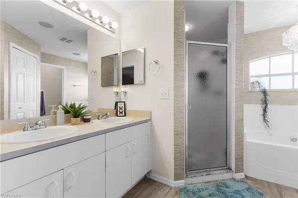 a bathroom with a double vanity sink mirror and bathtub
