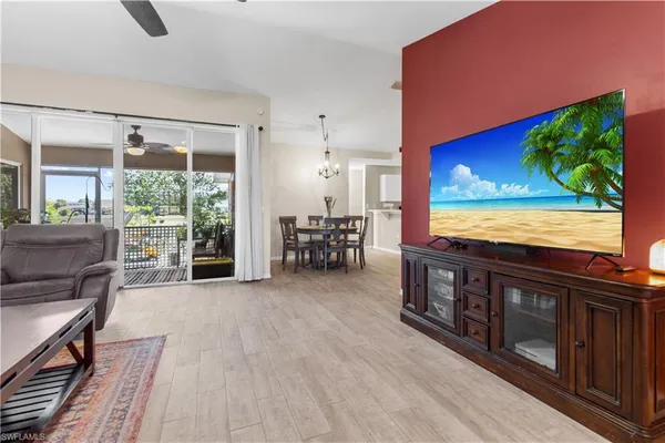 a living room with furniture a flat screen tv and a floor to ceiling window
