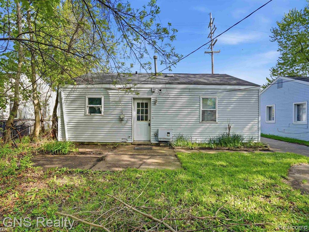 2717 Normandy Road Royal Oak, MI 48073 - Photo 2 of 13 Rear exterior featuring horizontal siding, a back door with window panes, and a small concrete patio