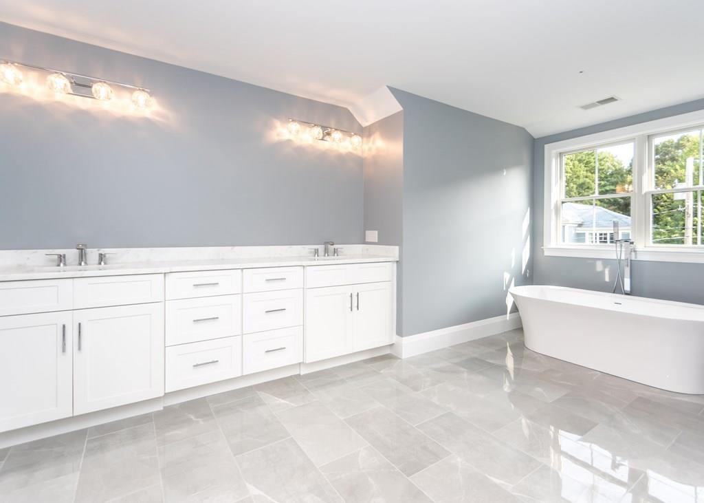 56 Pershing Road Needham, MA 02494 - Photo 21 of 42 a spacious bathroom with a double vanity sink a large mirror and a bathtub