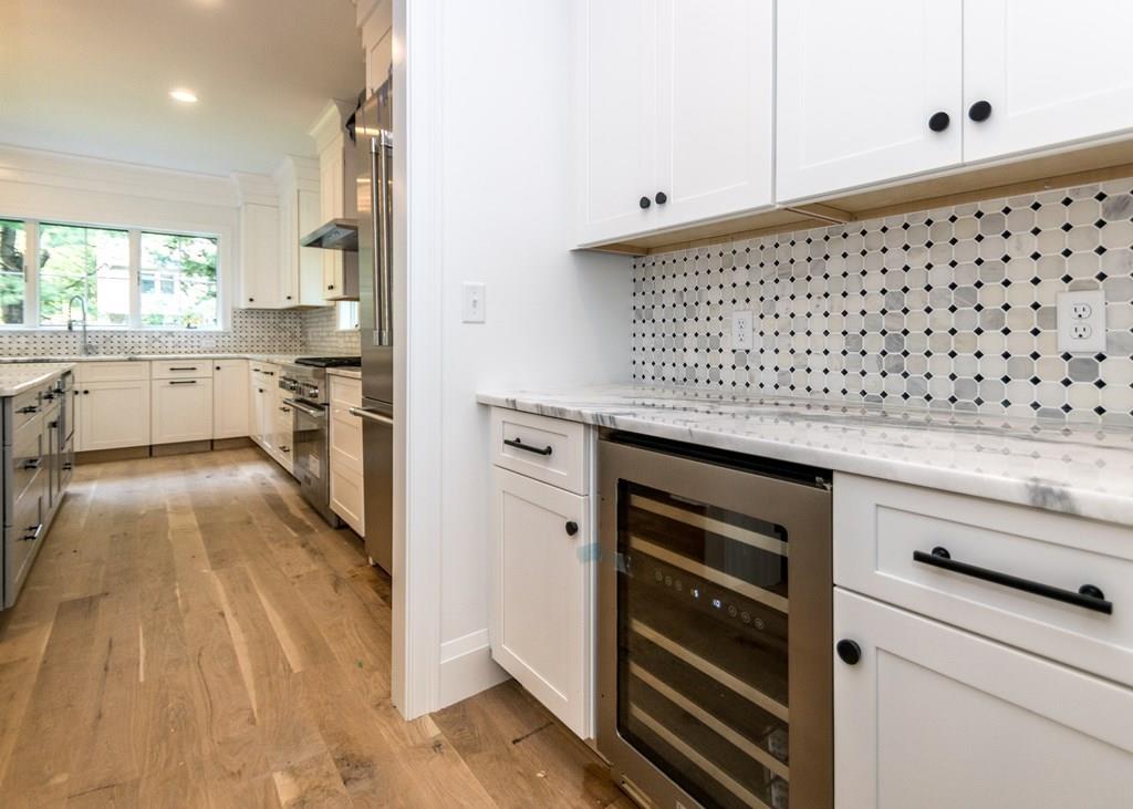 56 Pershing Road Needham, MA 02494 - Photo 7 of 42 a kitchen with granite countertop white cabinets and white appliances