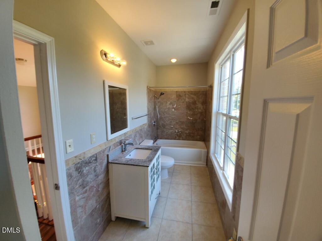 8007 Sundance Circle Durham, NC 27713 - Photo 14 of 23 a bathroom with a granite countertop sink a mirror and a bathtub