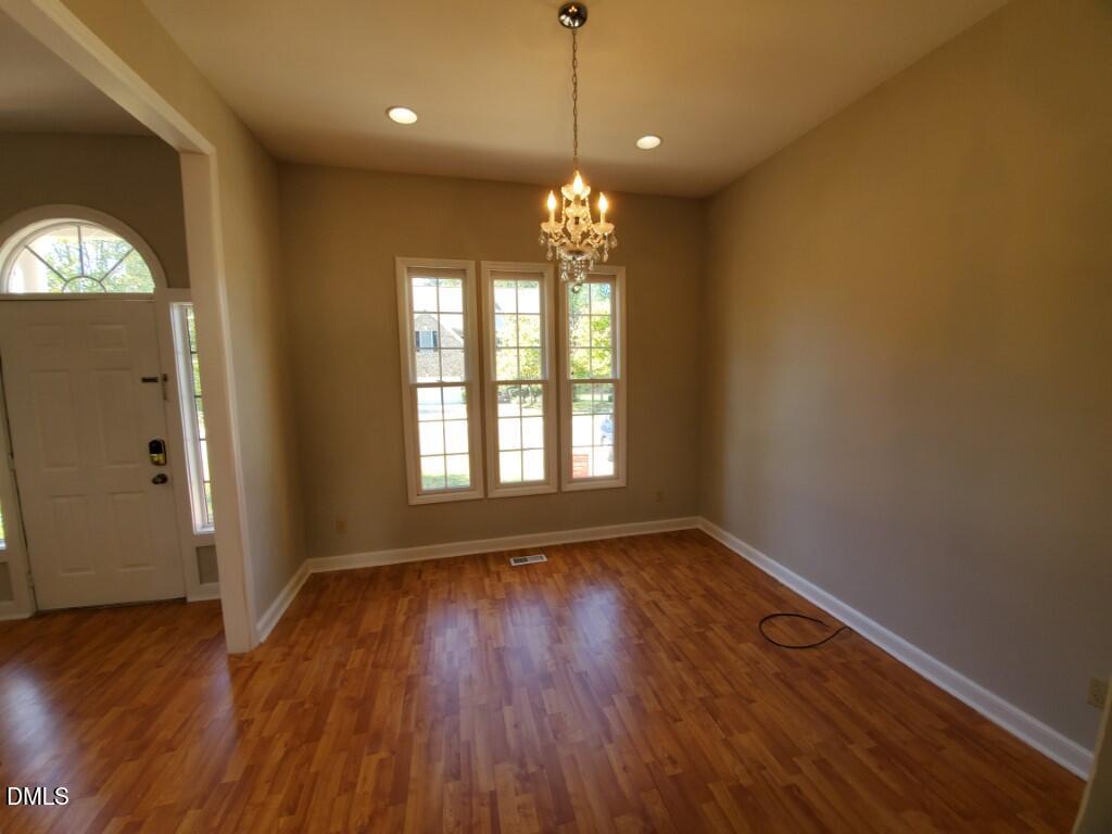 8007 Sundance Circle Durham, NC 27713 - Photo 6 of 23 a view of an empty room with wooden floor and a window