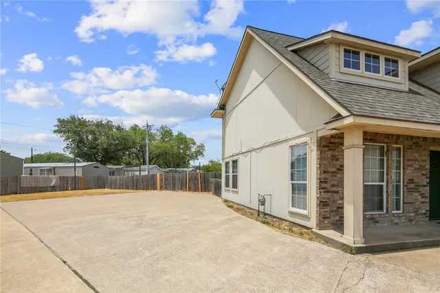 a view of a house with a wooden fence