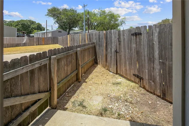 a view of a backyard with wooden fence